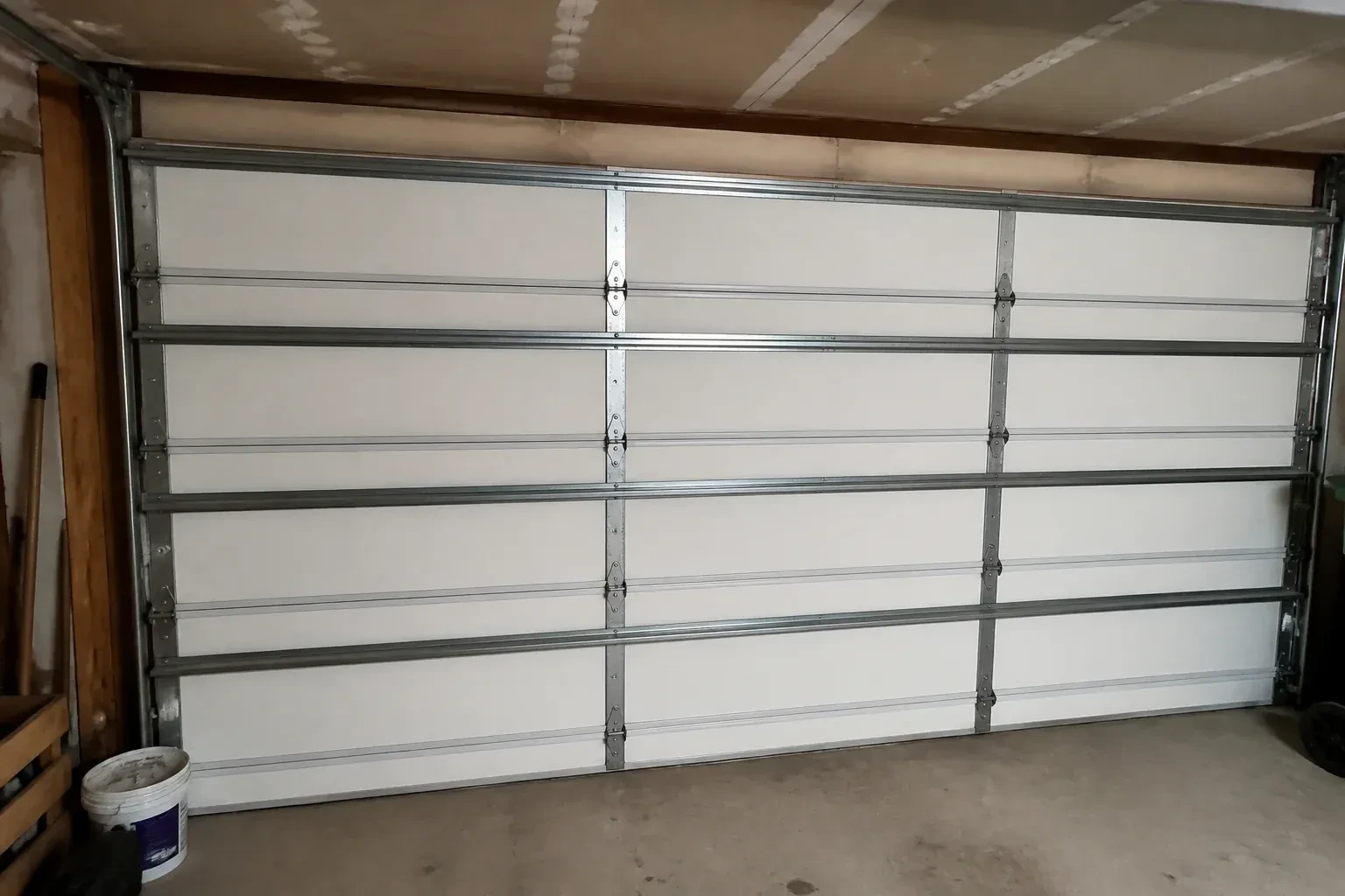 Interior of a closed sectional door with horizontal metal reinforcement struts. — Wind-Rated Garage Door Replacement, Hamilton